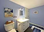 Full bathroom with a walk in shower is positioned between two bedrooms